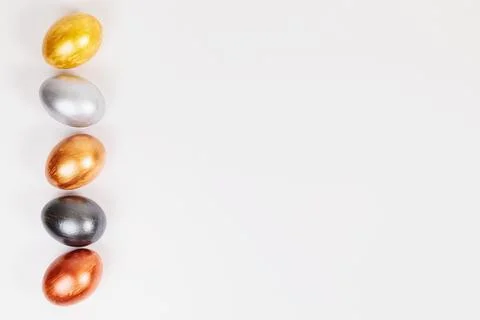 Multi-colored eggs on a uniform white background with place for text. Stock Photos