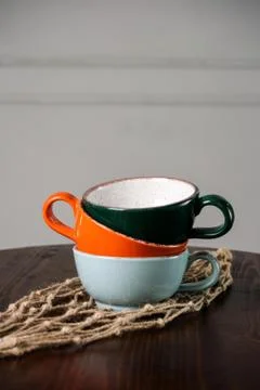 Multi-colored empty cups on the wooden table Stock Photos