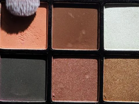 Multi-colored eyeshadow and makeup brush. Close-up Stock-Fotos
