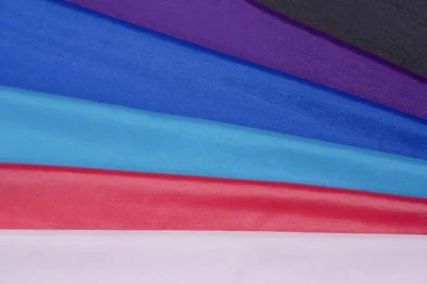 Multi-colored fabrics with a smooth texture and bright shades. Stock Photos