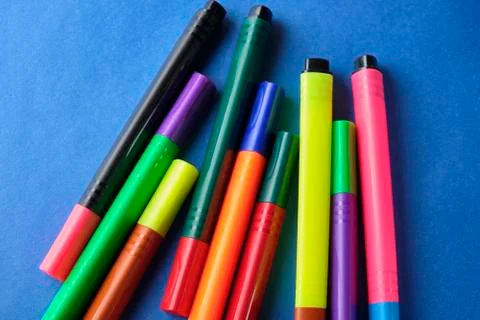 Multi colored felt pens with wrong color caps at blue background Stock Photos
