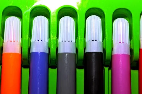 Multi-colored felt-tip pens with white caps in a green pencil case Stock Photos