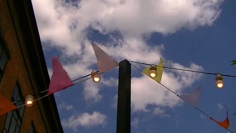 Multi-colored flags and light bulbs on the background sky Stock Footage 92624170