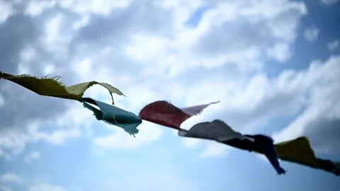 Multi-colored flags sway in the wind against the blue sky. Buddhism Video stock 247339512