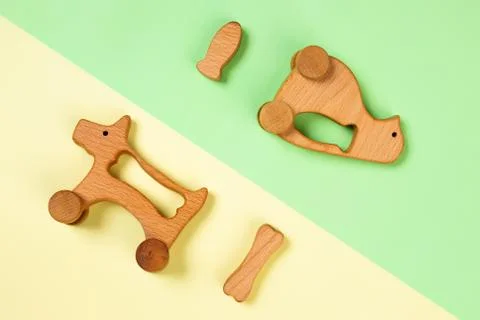 Multi-colored flat lay with eco-friendly wooden toys penguin with fish, dog w Stock Photos