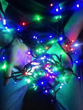 Multi-colored garlands in the hands of a guy. Stock Photos