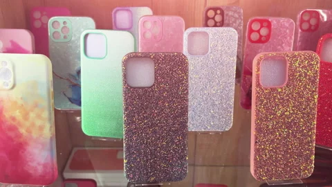 Multi-colored glitter silicone cases stand in the smartphone accessories window 스톡 동영상 211914857