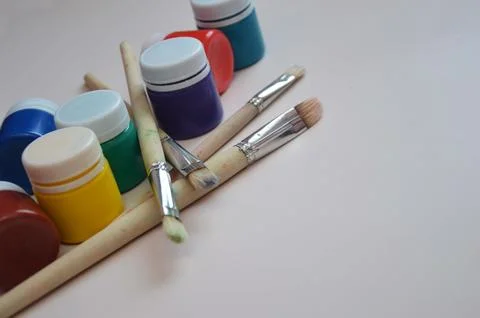 Multi-colored gouache paint in closed jars and brushes for artists. Set for.. Foto stock