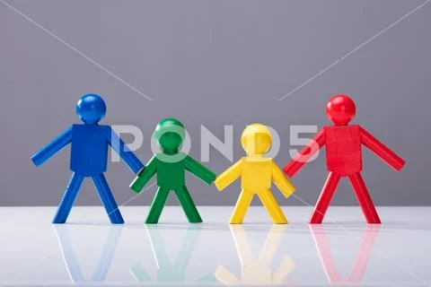 Multi Colored Human Figures Standing In A Row Stock Photos