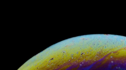 Multi-colored iris of a soap bubble in motion. black background. Stock Footage 114708175