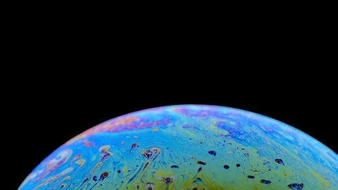 Multi-colored iris of a soap bubble in motion. black background. Stock Footage 114713191