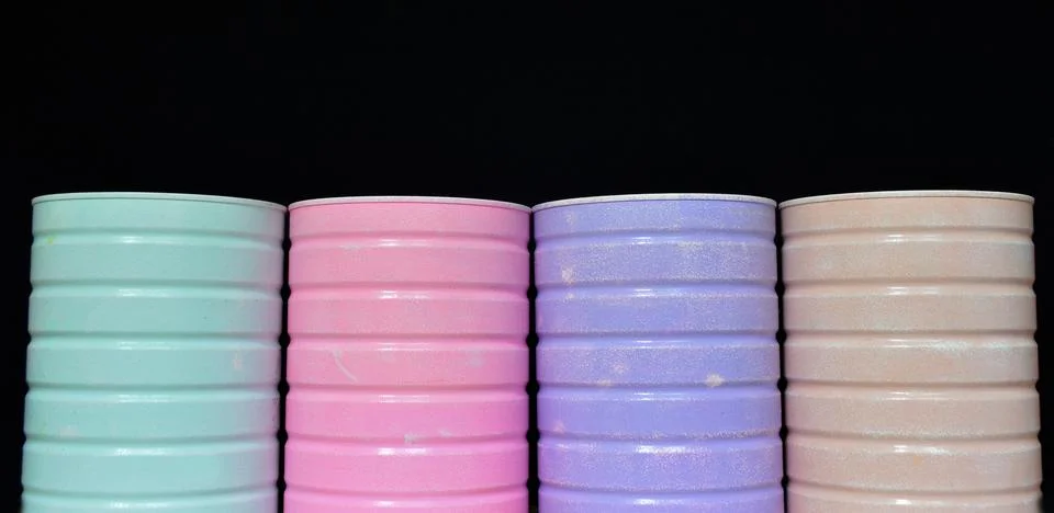 Multi-colored jars or containers for small items on a black background Stock Photos