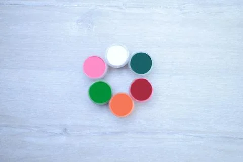 Multi-colored jars with paints, gouache on a white wooden background Stock Photos