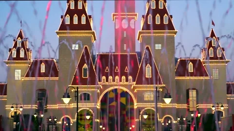 Multi-colored jets of the fountain against the backdrop of a fairy-tale castle. Stock Footage 208645146