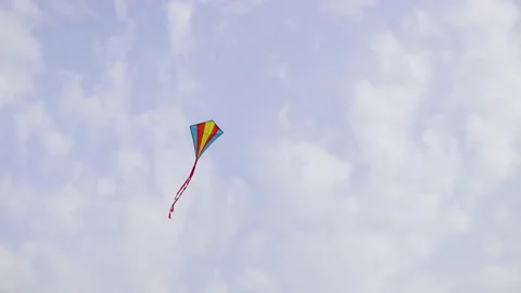 A multi-colored kite flying high in the sky under the gusts of wind. Stock Footage 243756347