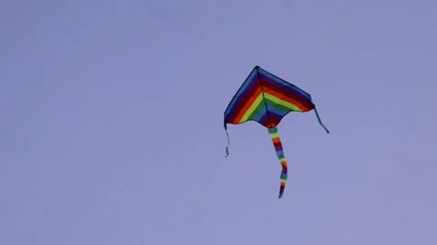 Multi-colored kite flying through the sky Stock Footage 134259052