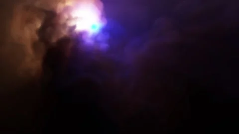 Multi-colored lights fly among dense puffs of smoke and paint it in different Stock Footage 169674316