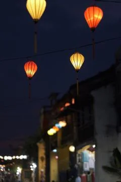 Multi-colored lights hanging on the wires of the decorative street illuminati Stock Photos