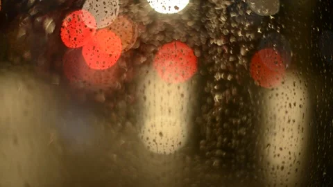 Multi-colored lights of night traffic and city lighting through a rain-splat Stock Footage 237098849