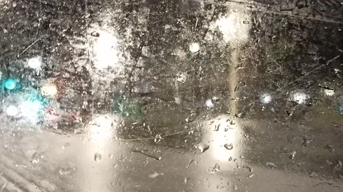 Multi-colored lights of night traffic and city lighting through a rain-splat Stock Footage 237099056