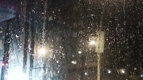 Multi-colored lights of night traffic and city lighting through a rain-splat Stock Footage 237099243