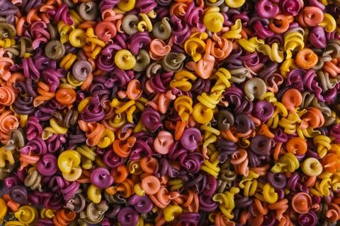 Multi-colored macaroni of an unusual form with natural vegetable dyes. Backgr Stock Photos