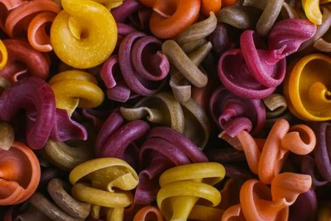 Multi-colored macaroni of an unusual form with natural vegetable dyes. Backgr Stock Photos
