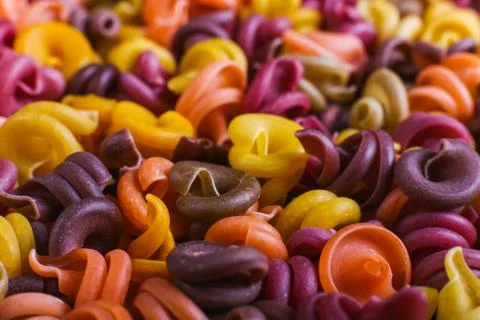 Multi-colored macaroni of an unusual form with natural vegetable dyes. Backgr Stock Photos