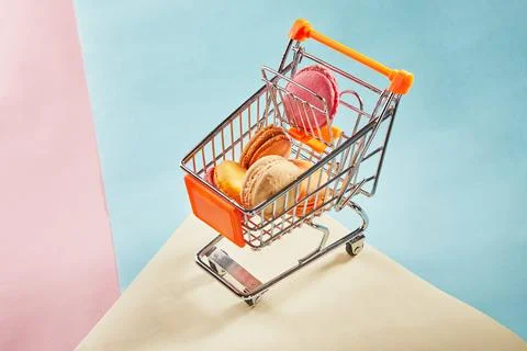 Multi-colored macarons of different colors and flavors in a supermarket troll Stock Photos