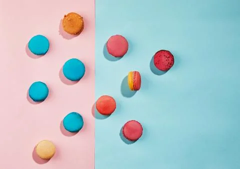 Multi-colored macaroons of different colors and flavors scattered on a blue-p Stock Photos