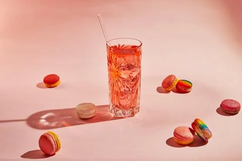 Multi-colored macaroons of different flavors and a glass with a drink on a .. Stock Photos