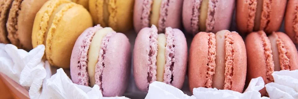 Multi-colored macaroons stacked in a row. Delicious French dessert Macaroon - Stock Photos