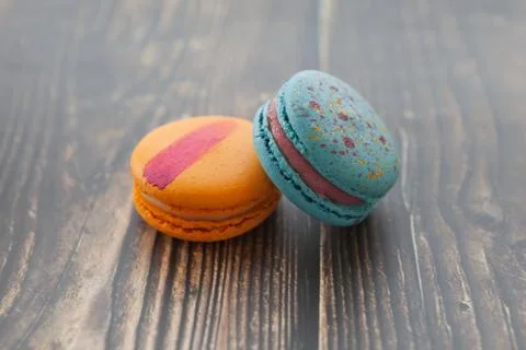 Multi-colored macaroons on a wooden table. Orange and blue macaroon. 写真素材