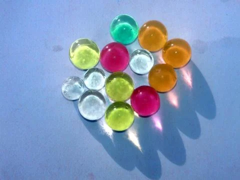 Multi colored marbel on light blue background Stock Photos