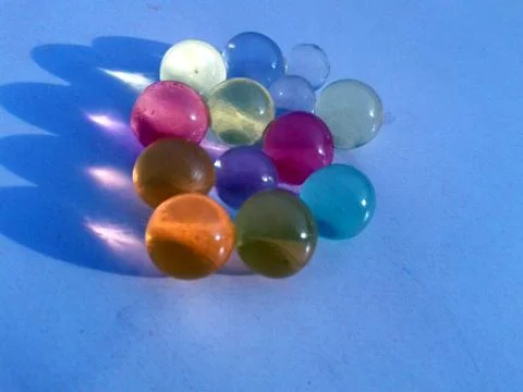 Multi colored marbel on light blue background Stock Photos