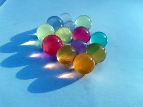 Multi colored marbel on light blue background Stock Photos