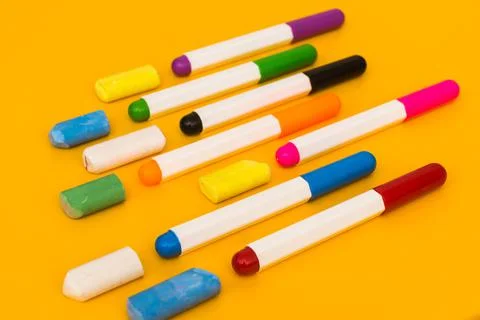 Multi-colored markers and crayons on a yellow background. Photo for drawing. Stock Photos