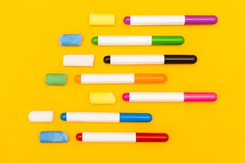 Multi-colored markers and crayons on a yellow background. Photo for drawing. Stock Photos