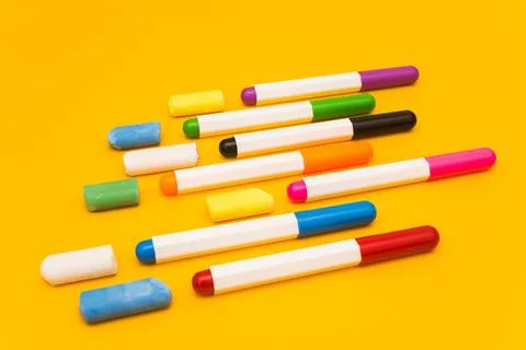 Multi-colored markers and crayons on a yellow background. Photo for drawing. Stock Photos