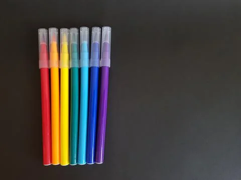 Multi-colored markers for drawing. Markers on a black isolated background Stock Photos