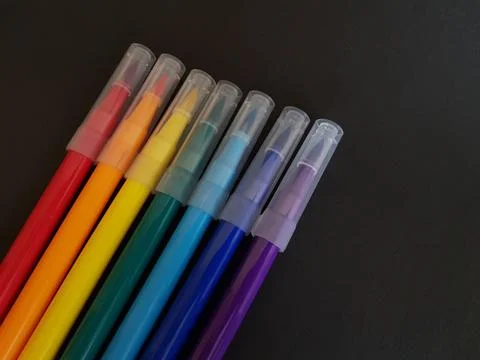 Multi-colored markers for drawing. Markers on a black isolated background Stock Photos