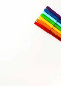 Multi-colored markers lie on a white background in a rainbow order in the upper Stock Photos