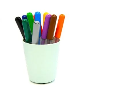 Multi colored markers in plastic cup isolated on a white background. Material Stock Photos