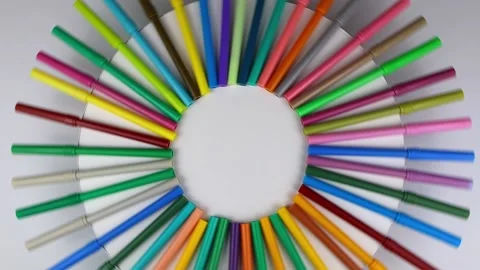 Multi-colored markers rotate 360 degrees on a round white table. Top view Vídeo Stock 140992605