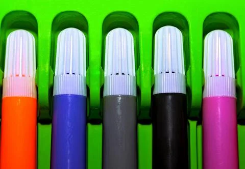 Multi-colored markers with white caps in a green pencil case Foto stock
