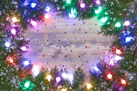Multi-colored matte luminous garlands on fir branches Stock Photos
