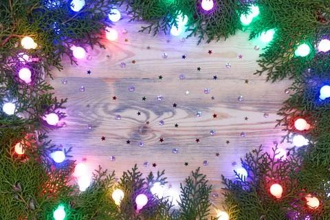 Multi-colored matte luminous garlands on fir branches. Christmas composition Stock Photos