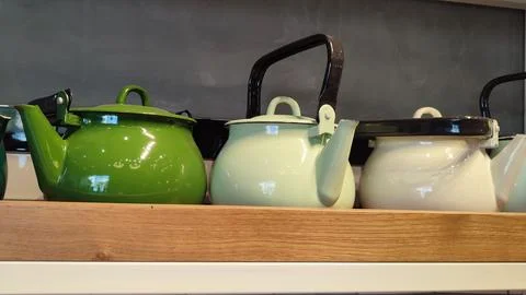 Multi-colored metal teapots for tea on a shelf in a store, kitchen objects Stock Photos