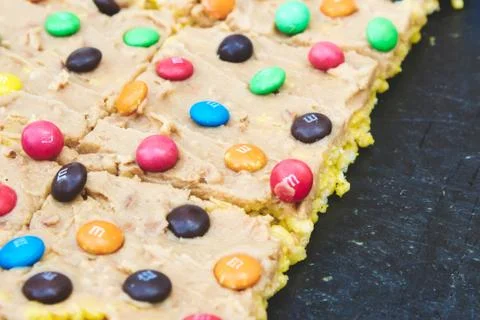 Multi-colored M&amp;Ms on a slice of homemade flapjack with icing, May 12th 2019 Stock Photos