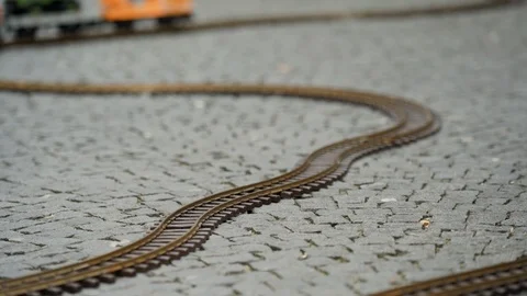 Multi colored model of freight train travels along the winding rails of the 스톡 동영상 115958758